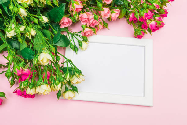 istock bouquet of small colored roses on a rose  background with frame top view 1150507758