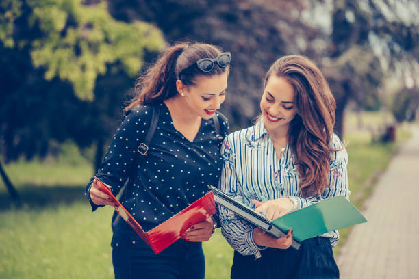 istock Two students learning reading a notebook and commenting in the street 1150508213