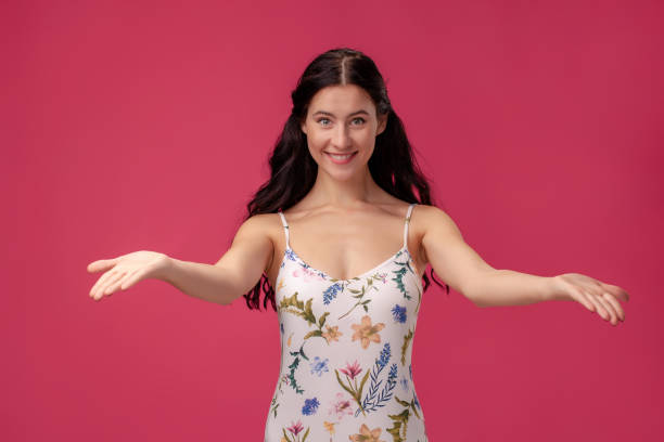 Close-up portrait of friendly pretty woman stretching her arms Close-up portrait of friendly pretty woman stretching her arms on pink background broad catch stock pictures, royalty-free photos & images