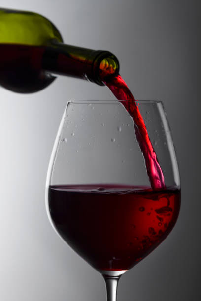 istock Red wine is poured from a bottle into a glass. 1150509529