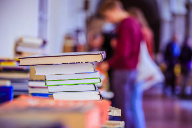 Stack of books at a charity book flea market, text space Stack of books, blurry background: Charity book flea market, outdoors. Text space. benefits of reading book stock pictures, royalty-free photos & images