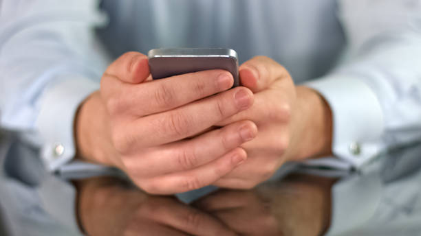 istock Man holding smartphone in hands closeup reading news, modern technology, app 1150510904