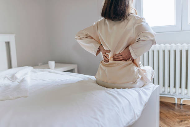 frau spürt rückenschmerzen massieren muskeln - backache massaging pain back stock-fotos und bilder