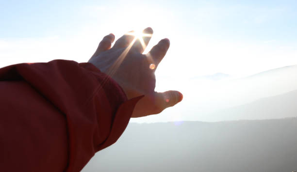 istock Hand reaches out towards the sun and mountains 1150512150