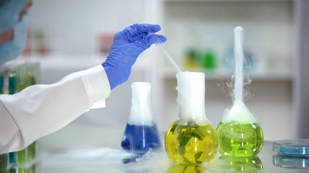 istock Biochemist taking yellow organic substance sample from flask, plant extraction 1150512269