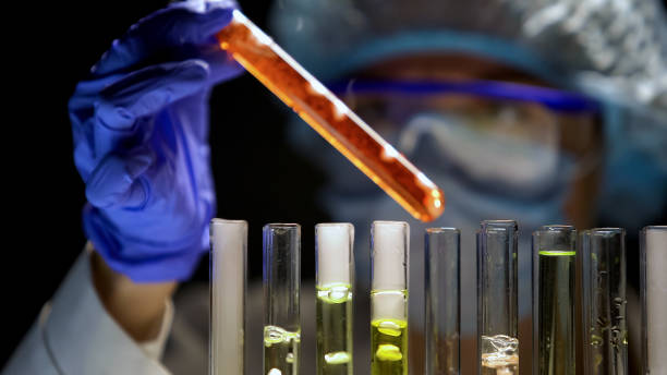 istock Lab assistant checking tube with orange liquid in darkness, special conditions 1150512332