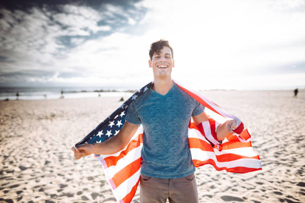 istock man with us national flag on the beach 1150512417