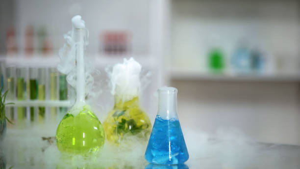 istock Multicolored chemical liquids in flasks bubbling and emitting smoke, reaction 1150512422
