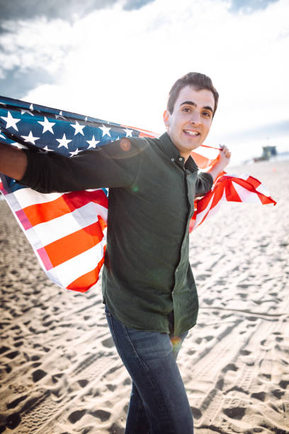 istock man with us national flag on the beach 1150512727