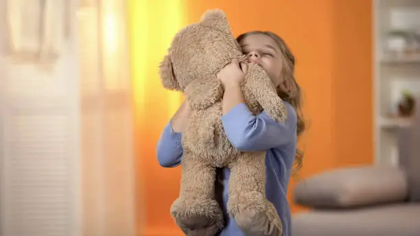 Photo of Cute little girl hugging teddy bear, favorite toy, happy childhood, best present