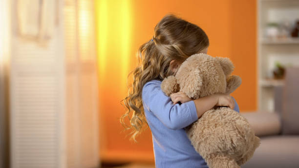 istock Small girl hugging teddy bear, problems with socialization, lack of friends 1150512797