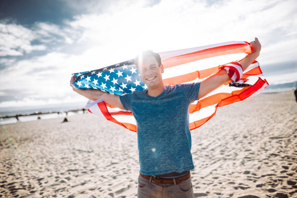 man with us national flag on the beach