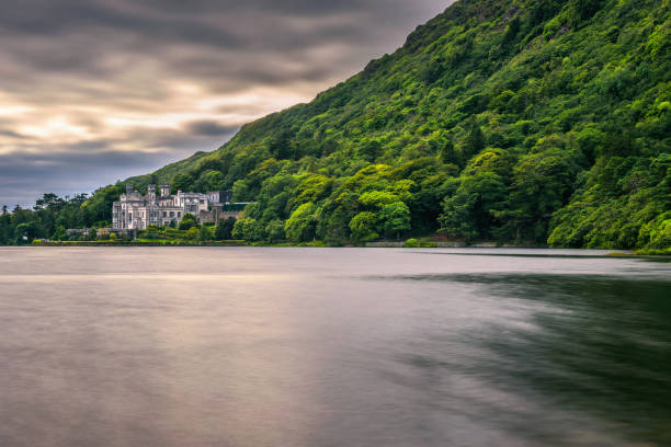 Kylemore Abbey in Ireland and the Pollacapall Lough Kylemore, Ireland - August 4, 2018 : Kylemore Abbey in Connemara, County Galway, Ireland with Pollacapall Lough. Kylemore Abbey is a Benedictine monastery founded in 1920 on the grounds of Kylemore Castle. Long exposure. kylemore abbey stock pictures, royalty-free photos & images