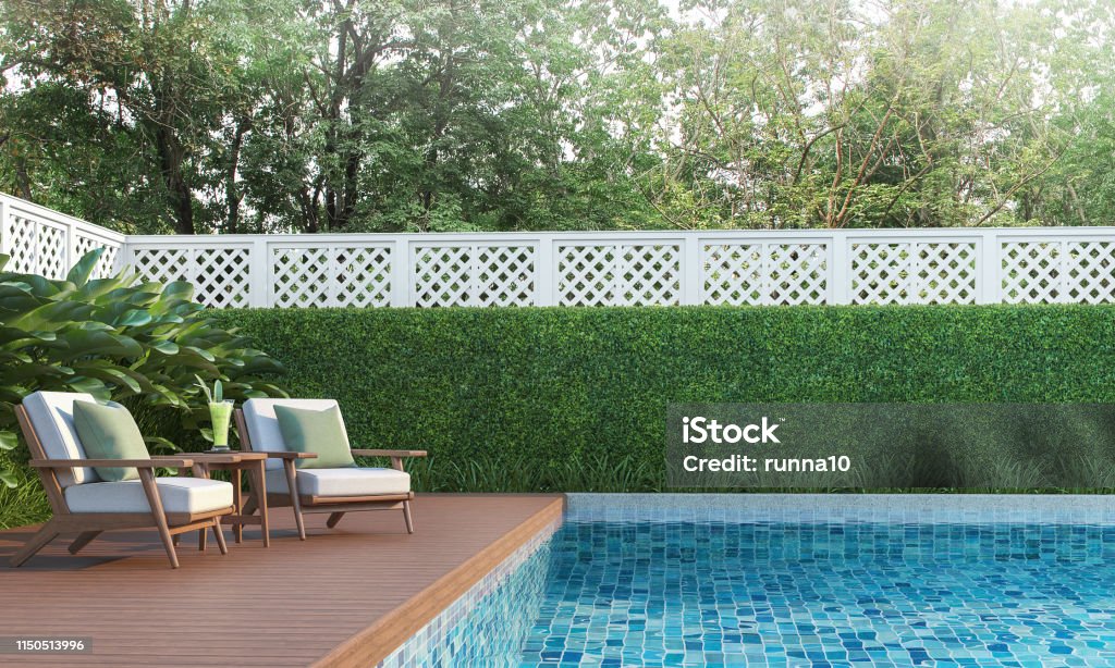 Swimming pool terrace in the garden 3d render Swimming pool terrace in the garden 3d render,  There are a wooden floor ,Blue tile in the swimming pool and white fence,Decorated with wooden and white fabric furniture,Surrounded by nature. Swimming Pool Stock Photo