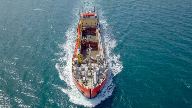 istock Red Trailing Suction Hopper-Dredger ship roaring across the sea 1150514338