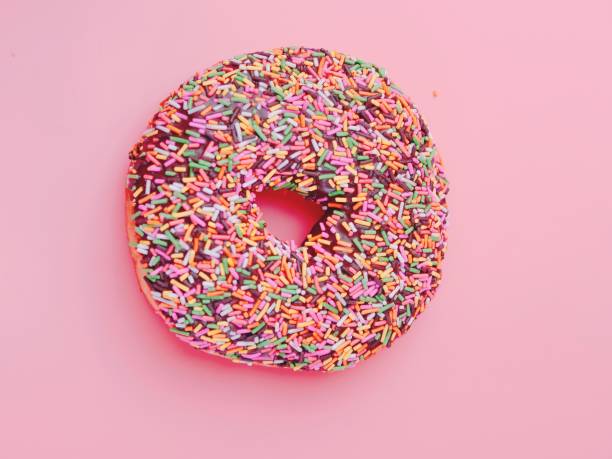 istock Pink glazed donut with colored sugar topping 1150514811