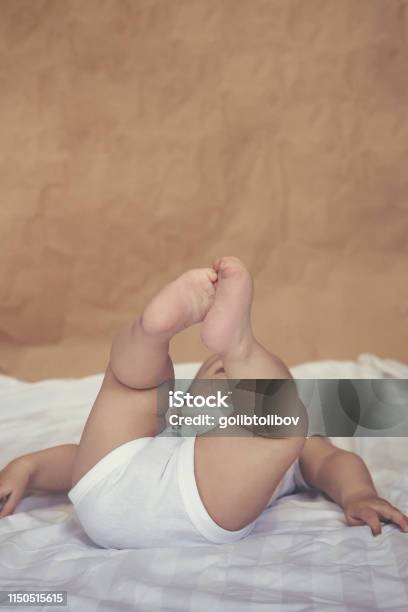 68 Month Old Baby Boy Lying Playfully In Bed Stock Photo - Download Image Now - 0-11 Months, 6-11 Months, Arm