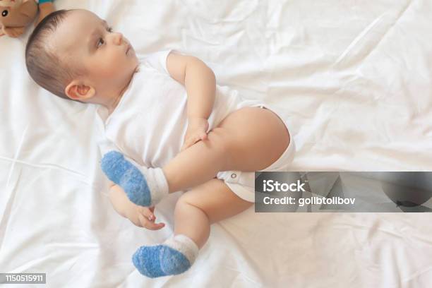 68 Month Old Baby Boy Lying Playfully In Bed Stock Photo - Download Image Now - 0-11 Months, 6-11 Months, Arm