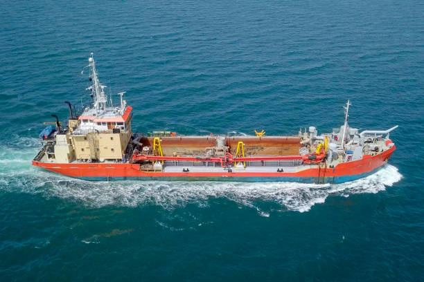 istock Red Trailing Suction Hopper-Dredger ship roaring across the sea 1150516247