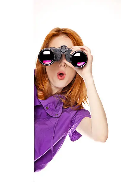 Photo of Teen redhead girl with binoculars isolated on white background