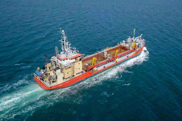 istock Red Trailing Suction Hopper-Dredger ship roaring across the sea 1150516743