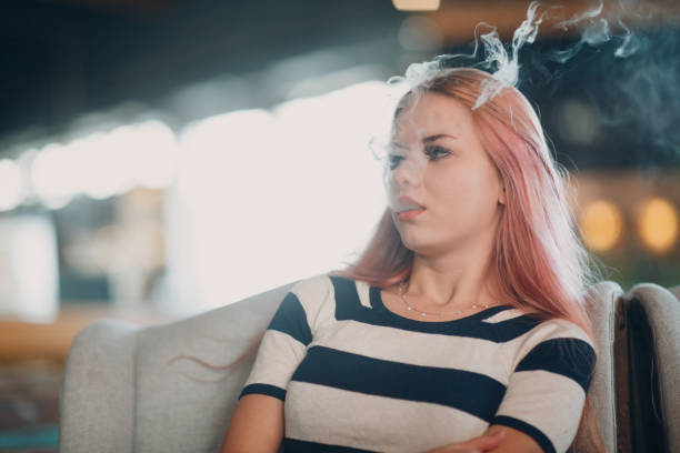 istock Young woman smoking electronic cigarette. Vape concept. 1150517147