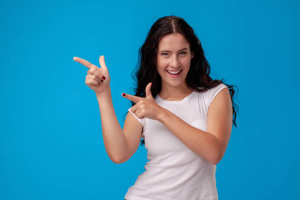 istock Woman making gun gesture on blue background 1150517879