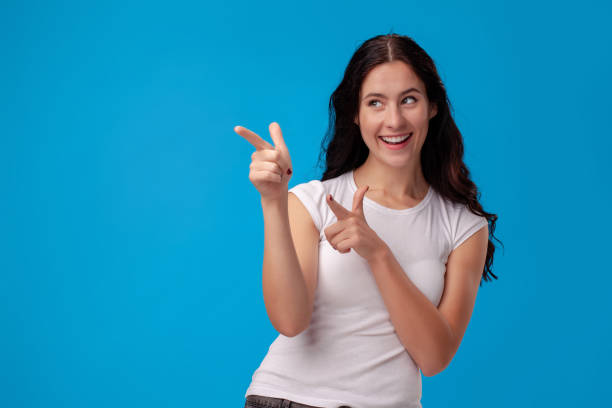 istock Woman making gun gesture on blue background 1150517888
