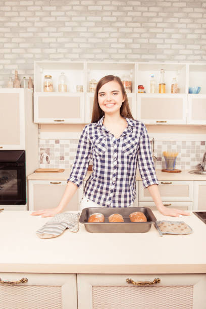 istock Cheerful woman smiling in the kitchen with baked bread 1150518491