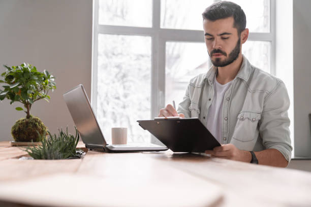 istock Young businessman going through paperwork at office 1150518763