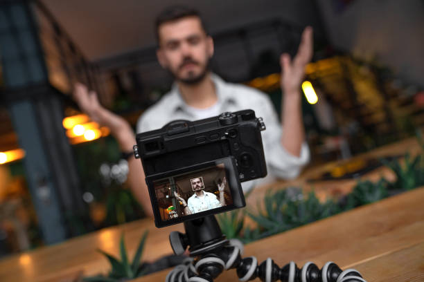 un blogger de negocios macho caucásico graba vídeo para su vlog en cámara digital - content fotografías e imágenes de stock