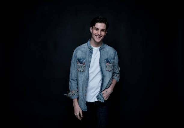 istock Good looking man wearing a button down shirt in front of black background 1150520300