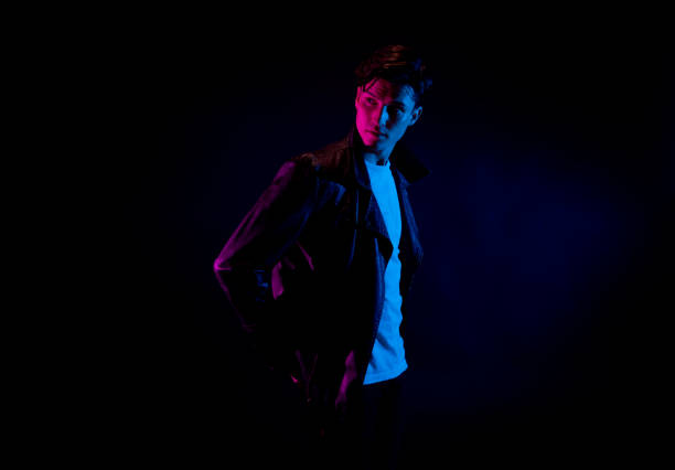 istock Good looking man wearing a leather jacket in front of black background 1150520309