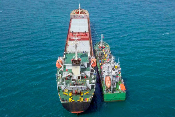 Refuelling at sea, Aerial image of a Small Oil products ship fuelling a large Bulk carrier. stock photo