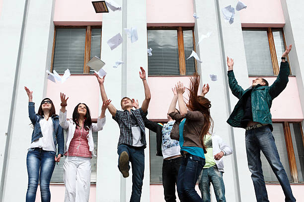 A group of students jump in the air stock photo