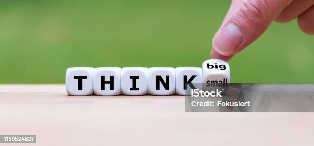 Hand Turns A Dice And Changes The Expression Think Small To Think Big Stock Photo - Download Image Now