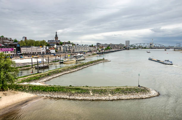Nijmegen, The Netherlands, April 25, 2019: view from the old Waal bridge towards the river and the city, with a breakwater in the foreground
