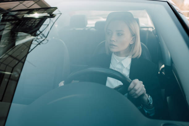 istock pensive blonde driver holding steering wheel while driving car 1150526798