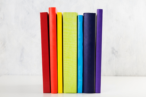 Stack of colorful rainbow books on white background