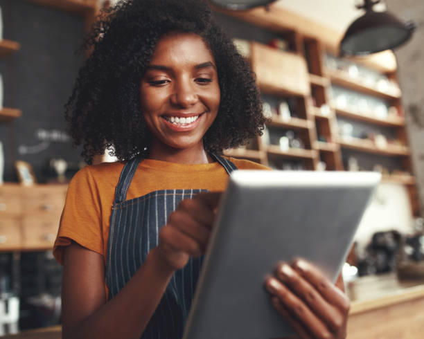 istock Smiling female cafe owner using digital tablet 1150528223