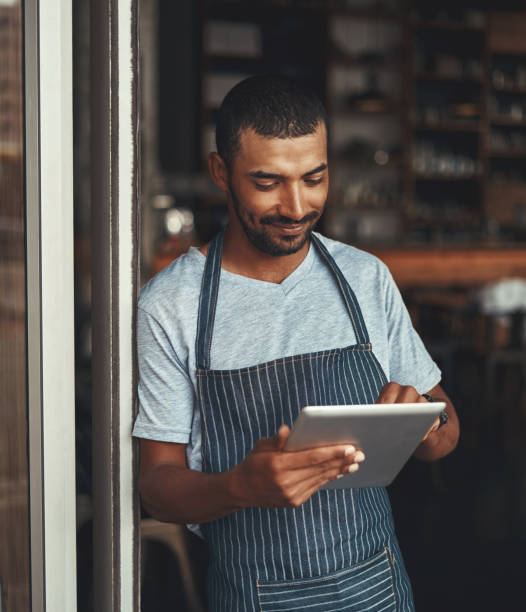 istock Young male entrepreneur using digital tablet at the cafe entranc 1150528508
