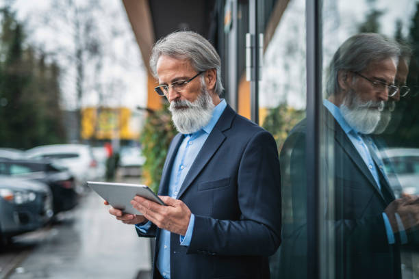 istock Caucasian senior businessman using a digital tablet outside his hotel 1150530342