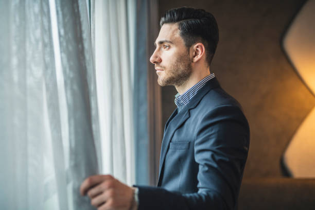 istock Businessman standing next to a window and looking at the view 1150530352