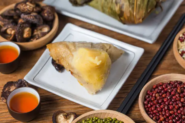 Photo of A woman is giving zongzi(rice dumpling) to others as a present on Dragon Boat Festival, Asian traditional food,