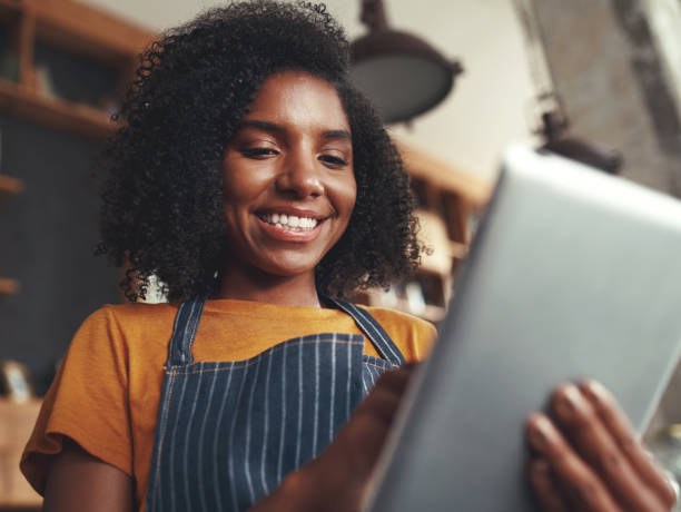 istock Female barista standing in coffee shop using digital tablet 1150531604
