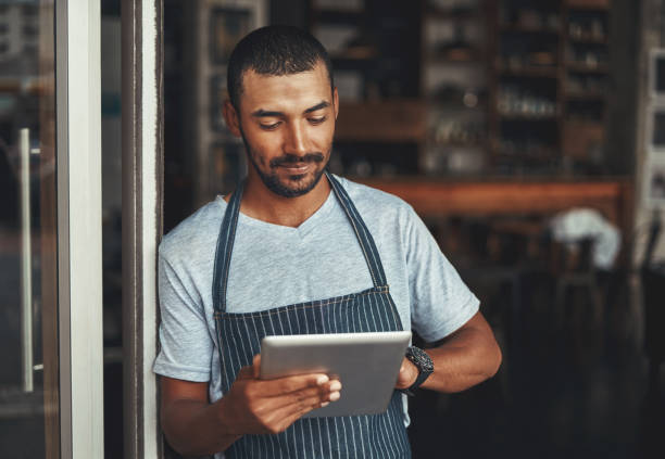 istock Young male cafe owner using digital tablet 1150531870