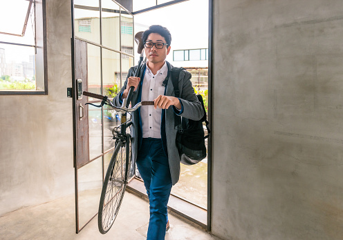 A man carrying his bike into his workplace in Taipei, Taiwan.