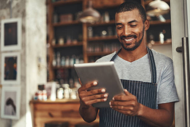 istock Successful barista cafe owner looking at digital tablet 1150533102