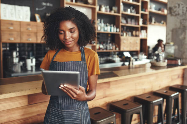 istock Successful small business owner using digital tablet in her cafe 1150533743