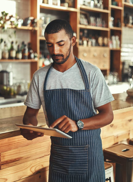 istock Small business owner at his coffee shop using digital tablet 1150533971